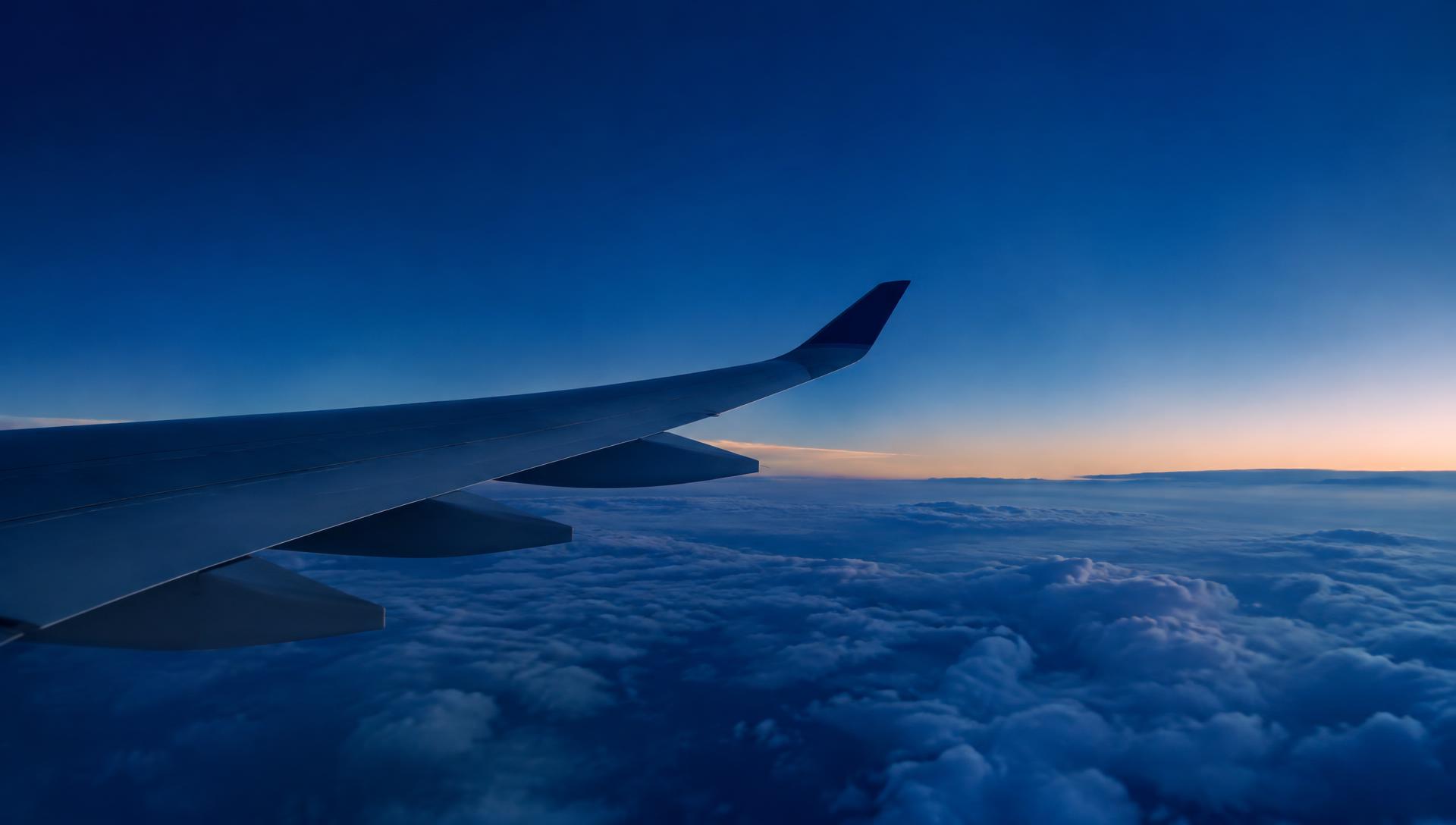 Aircraft wing above the clouds at dusk